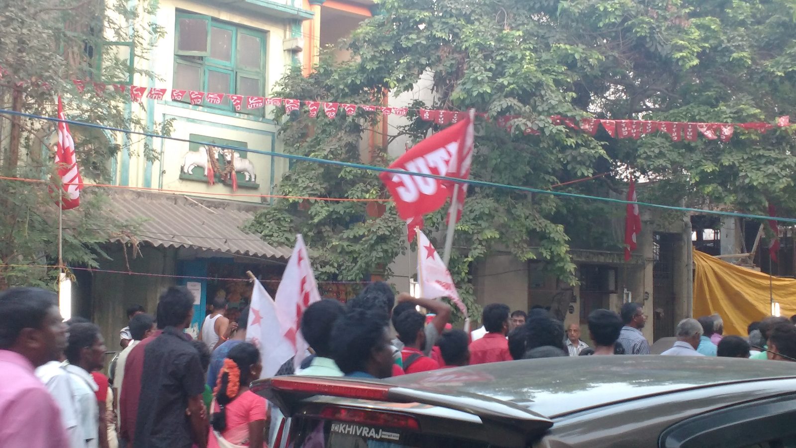 Protesters carrying red CITU trade union flags at a street demonstration